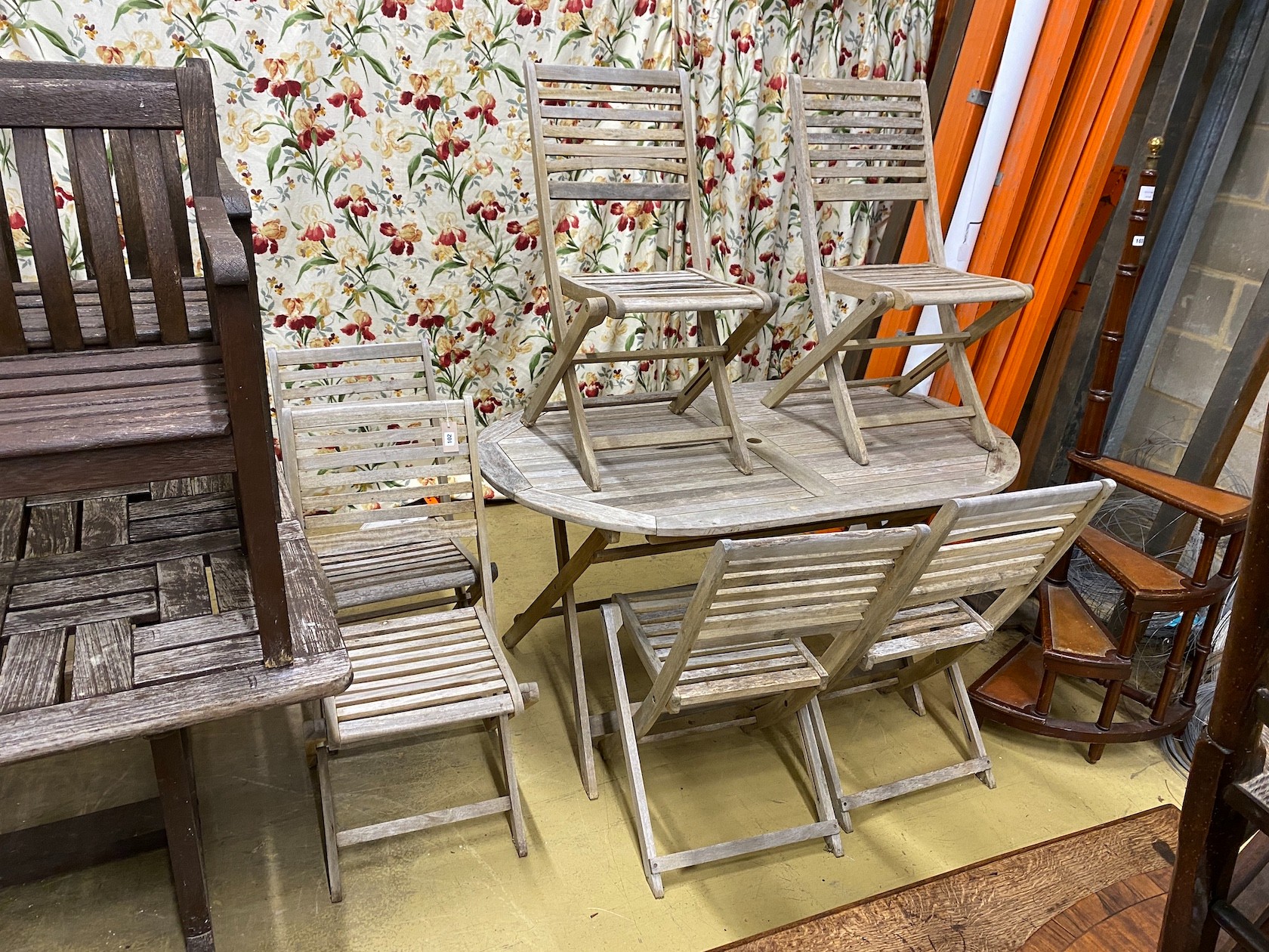 A weathered teak folding garden table, length 152cm, width 90cm, height 75cm and six teak folding garden chairs